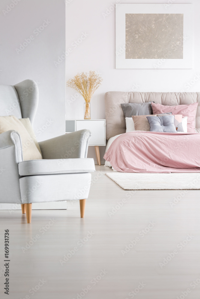 Grey armchair in trendy bedroom - obrazy, fototapety, plakaty 