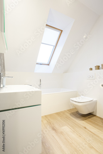 White bathroom with wooden floor