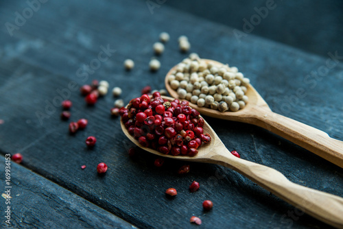 Two wooden spoons with pink and white peppercorn photo