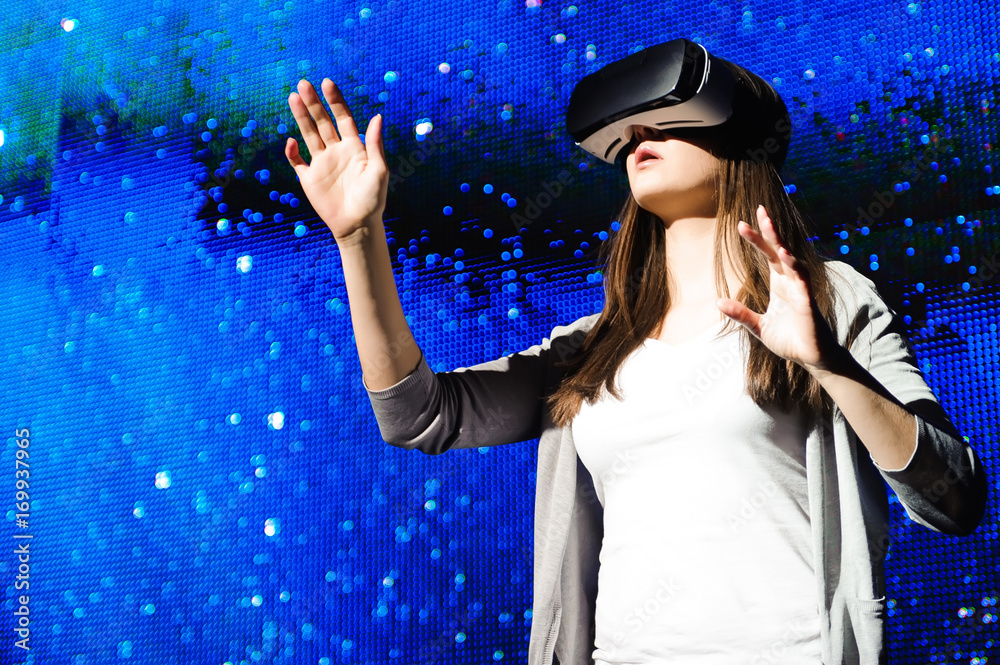 a beautiful girl wearing a virtual reality device, standing on the background of the sky a beautiful girl wearing a virtual reality device, standing on the background of the sky