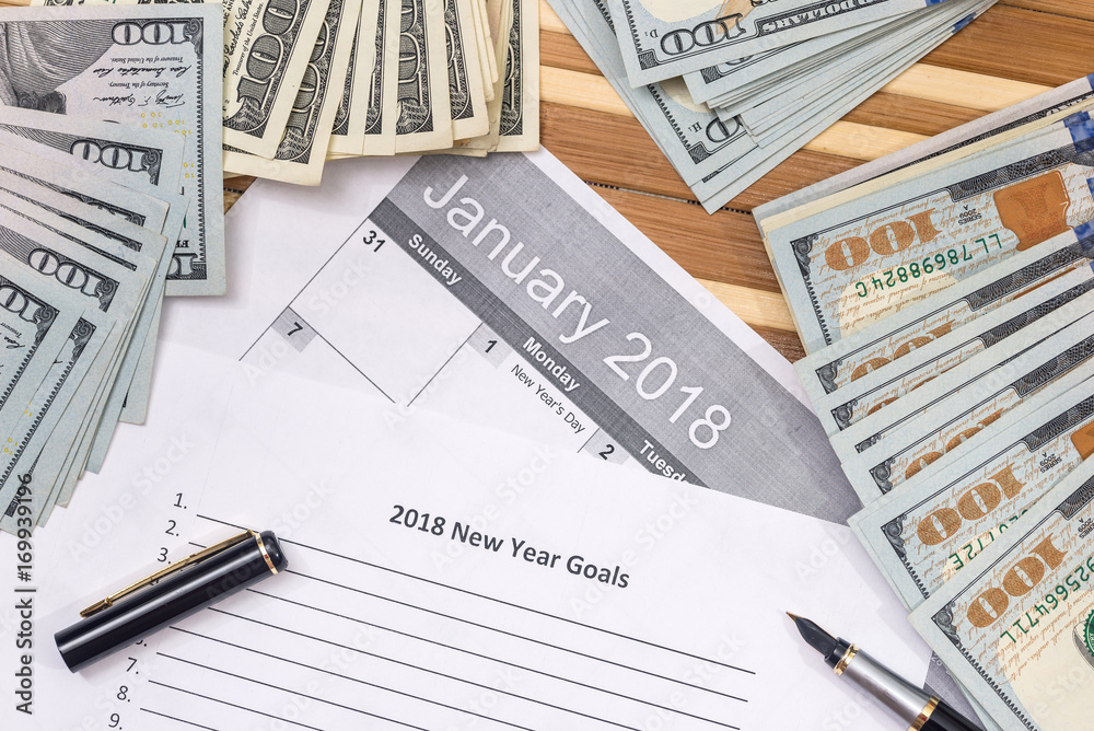 new year goals with calendar, dollar and pen new year goals with calendar, dollar and pen