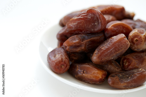 Bowl of dried dates isolated on white backgroun