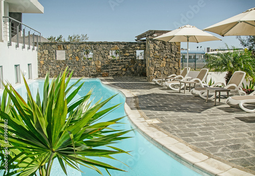 Nice swimming pool with deck cahirs and small palm photo