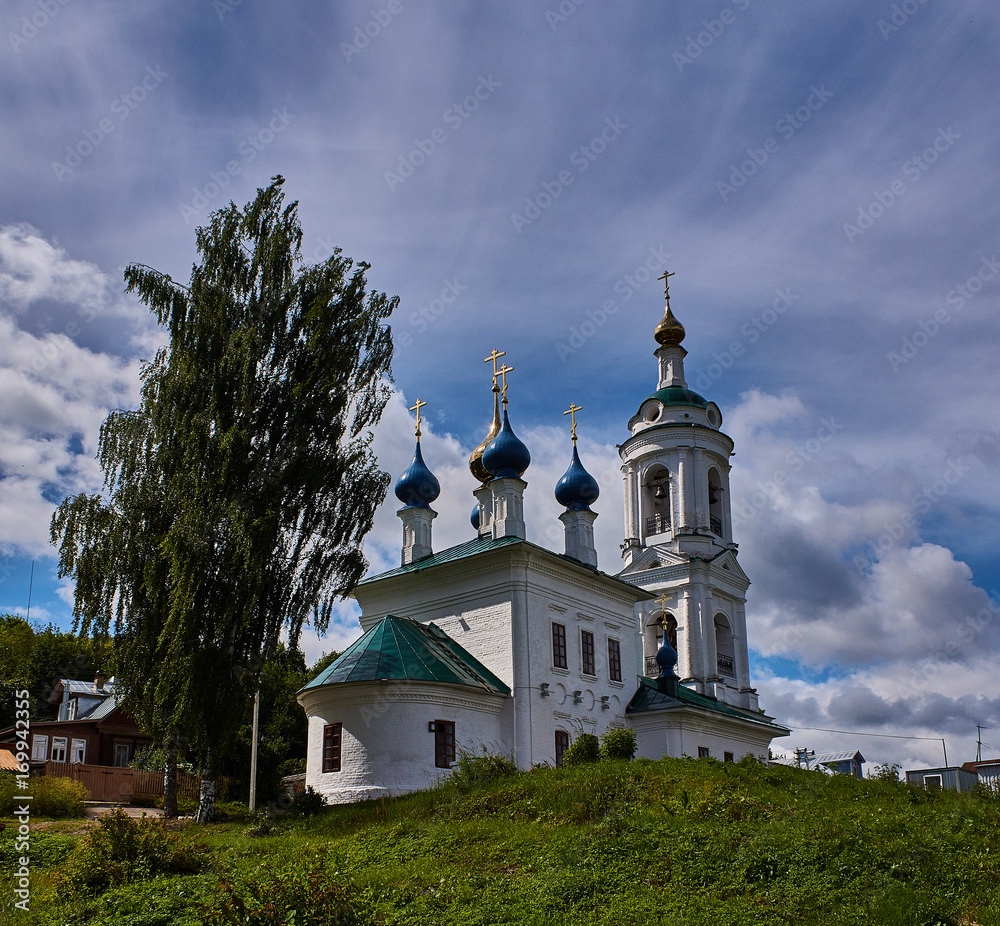 Orthodox temple on the hill/The white Orthodox church stands on a hill. Birch grows nearby. Plyos, Ivanovo region, Russia. The Golden ring of Russia