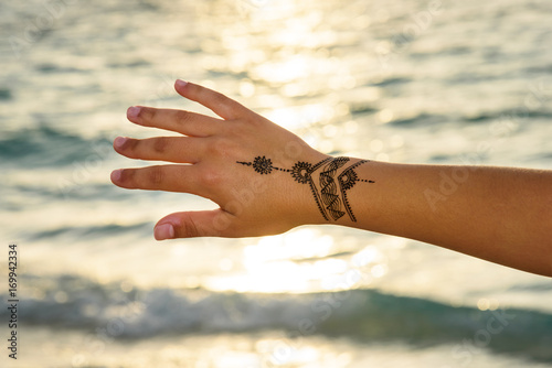 henna  tattoo painting on the  hand photo