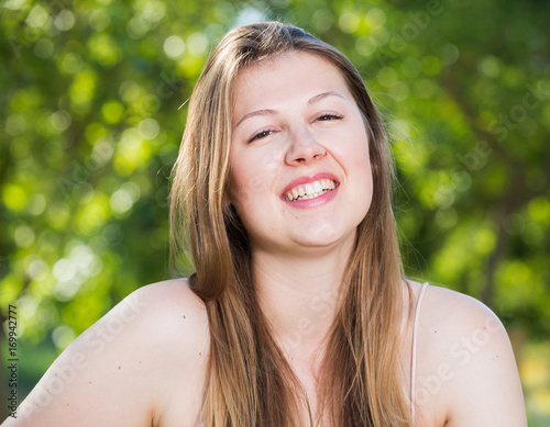 Cheerful girl is laughing while sitting on bench