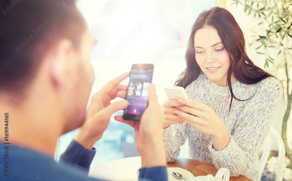 happy couple with smartphones drinking tea at cafe happy couple with smartphones drinking tea at cafe