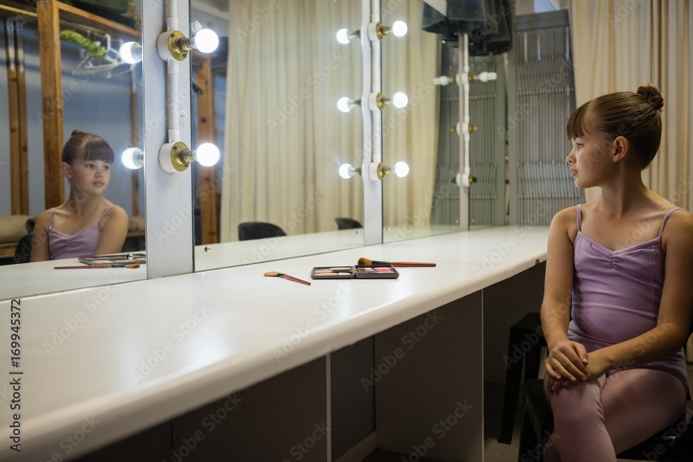 Girl looking in mirror while sitting on chair