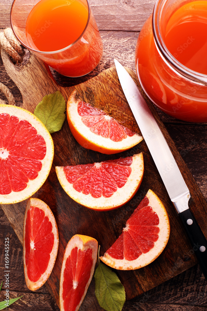 Grapefruit juice and ripe grapefruits on a wooden background Grapefruit juice and ripe grapefruits on a wooden background