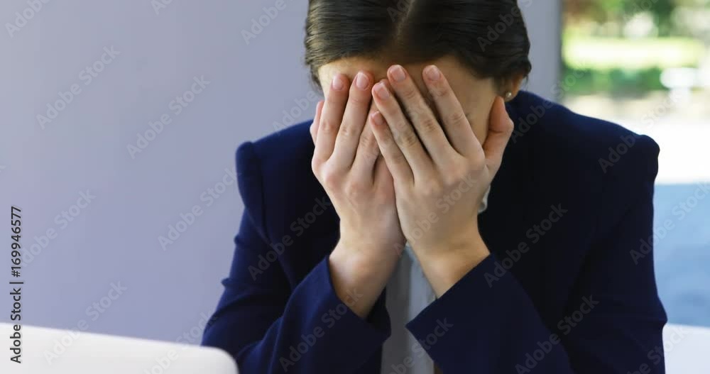 Businesswoman crying at desk 