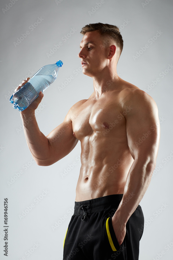 young man or bodybuilder with bottle of water