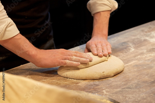 chef or baker cooking dough at bakery