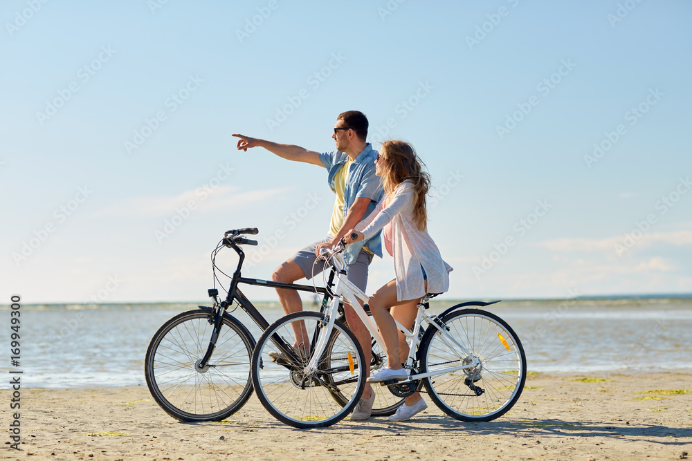 happy young couple riding bicycles at seaside happy young couple riding bicycles at seaside