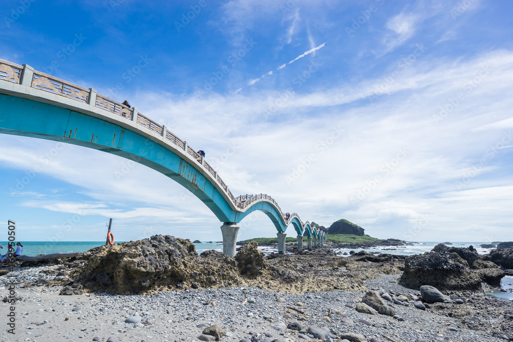 Fototapeta premium Panoramic view of Sansiantai bridge with beautiful sea level and reef rocks under fantasy blue cloudy and sunshine sky in Sansiantai Taitung. the famous attractions in Taiwan.