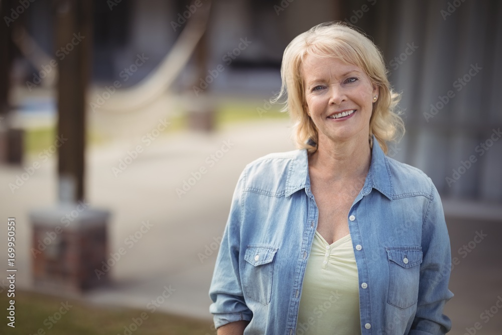 Senior woman smiling outside her house