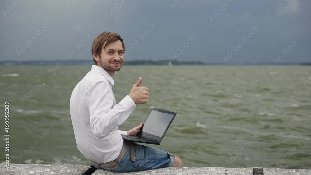 Man using laptop against the background of the storm Man using laptop against the background of the storm