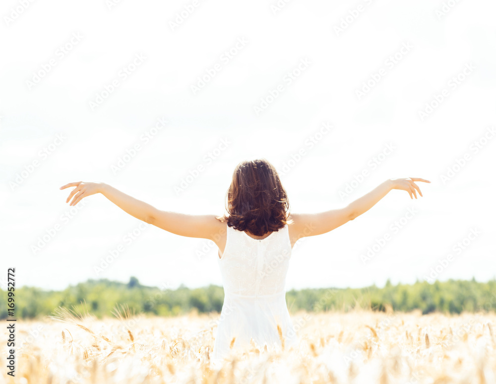 Beautiful and happy girl in a white dress walking in a meadow at summer. Beautiful and happy girl in a white dress walking in a meadow at summer.