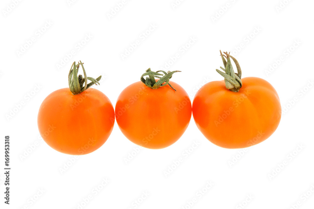 three small orange tomatoes on a white background three small orange tomatoes on a white background