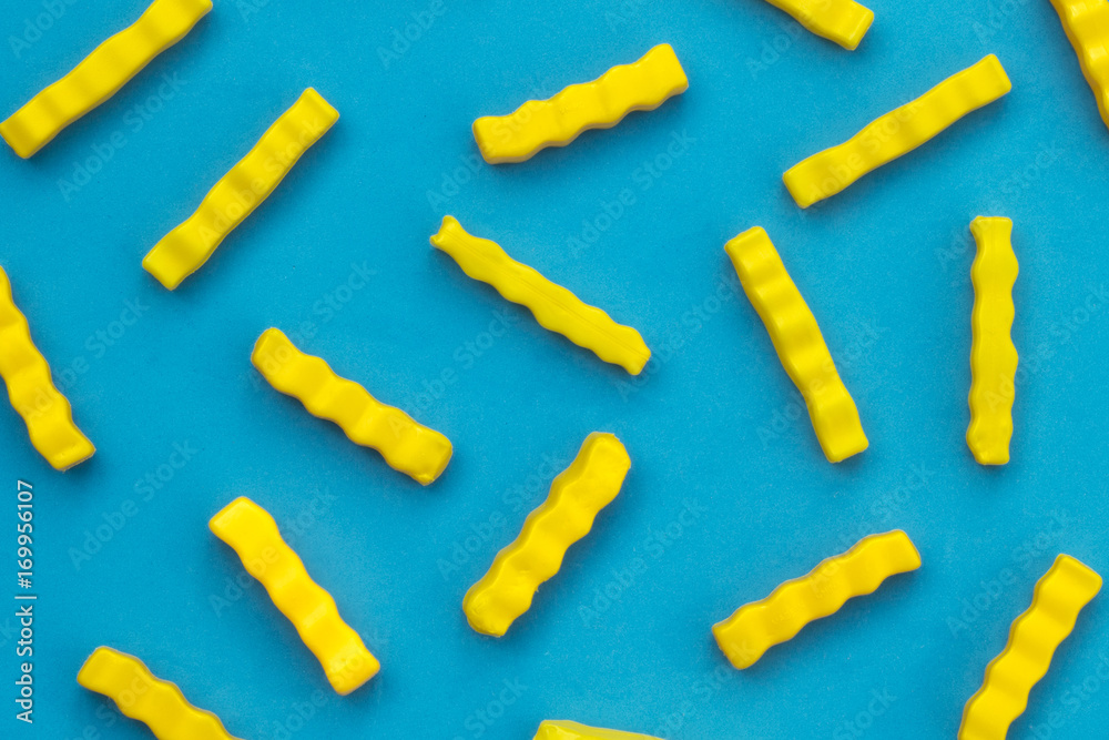 Plastic yellow potato chips in blue background Plastic yellow potato chips in blue background