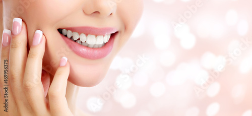 Closeup shot of beautiful female smile, abstract background with blurred lights