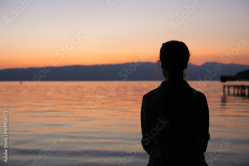 Silhouette of young woman on beach sunset.