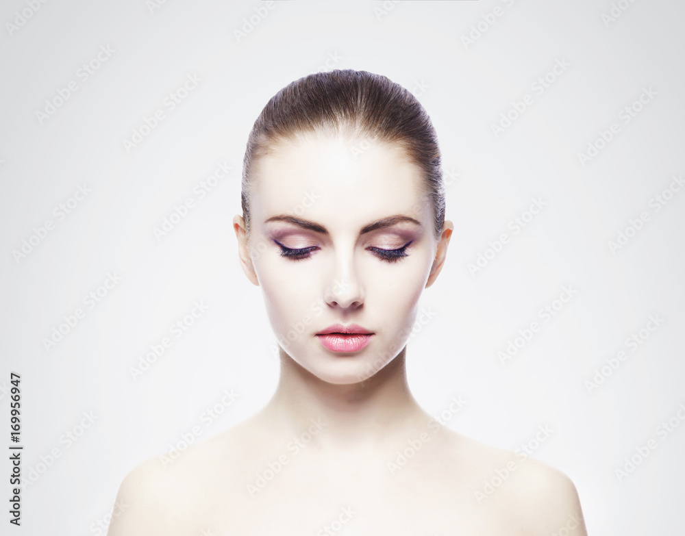 Portrait of young, beautiful and healthy woman: over cold grey background. Healthcare, spa, makeup and face lifting concept.