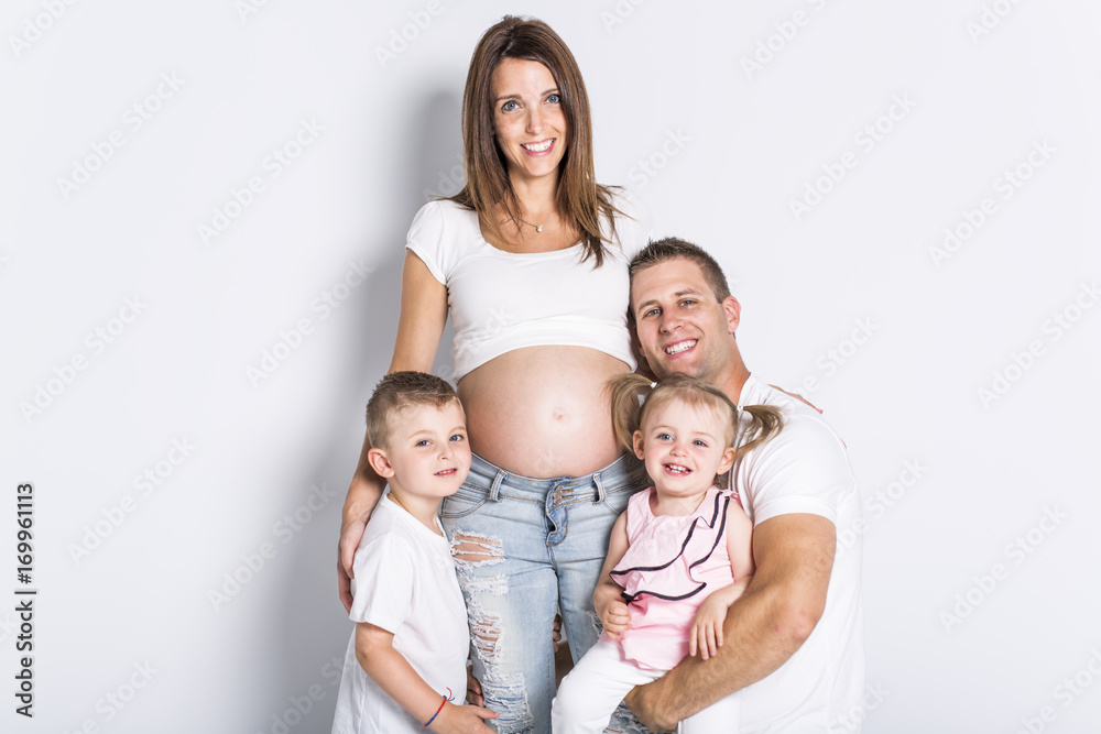 Happy family with two kids on studio gray background Happy family with two kids on studio gray background
