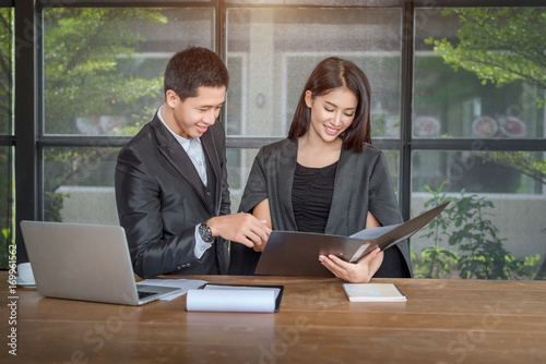 Two successful businessman Stand at the table and discussing business at the a laptop in a coffee shop. Businessmen dressed in formal wear