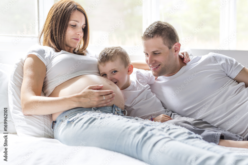 father, son and pregnant mother at home. Beautiful loving family portrait father, son and pregnant mother at home. Beautiful loving family portrait