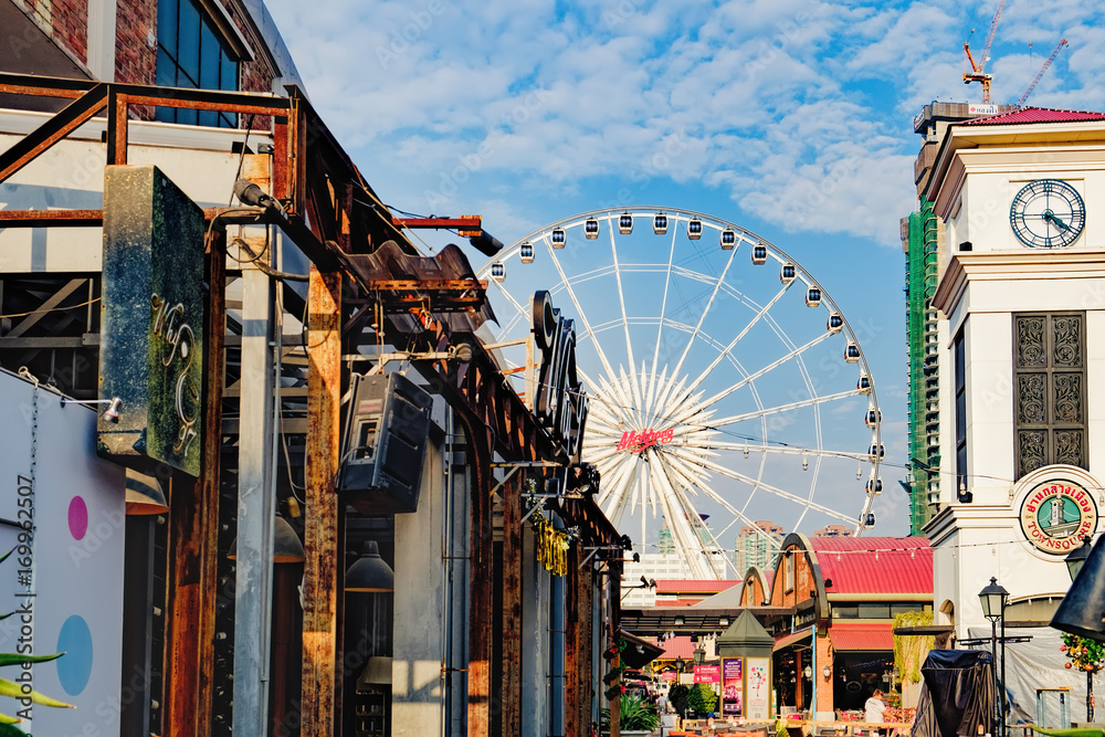 Fototapeta premium Asiatique shopping mall with Asiatique Ferris Wheel in background. Asiatique is largest lifestyle shopping mall in Bangkok, Thailand