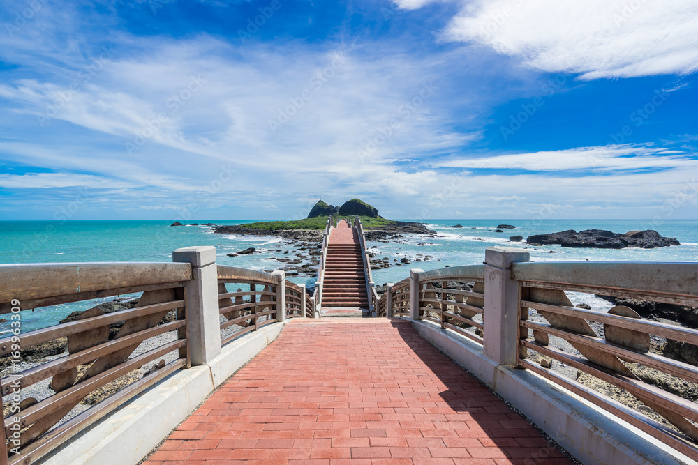 Obraz premium Panoramic view of Sansiantai bridge with beautiful sea level and reef rocks under fantasy blue cloudy and sunshine sky in Sansiantai Taitung. the famous attractions in Taiwan.
