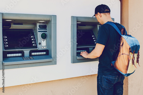 The tourist withdraws money from the ATM for further travel. Finance, credit card, withdrawal of money. Life style. Journey. Vacation.