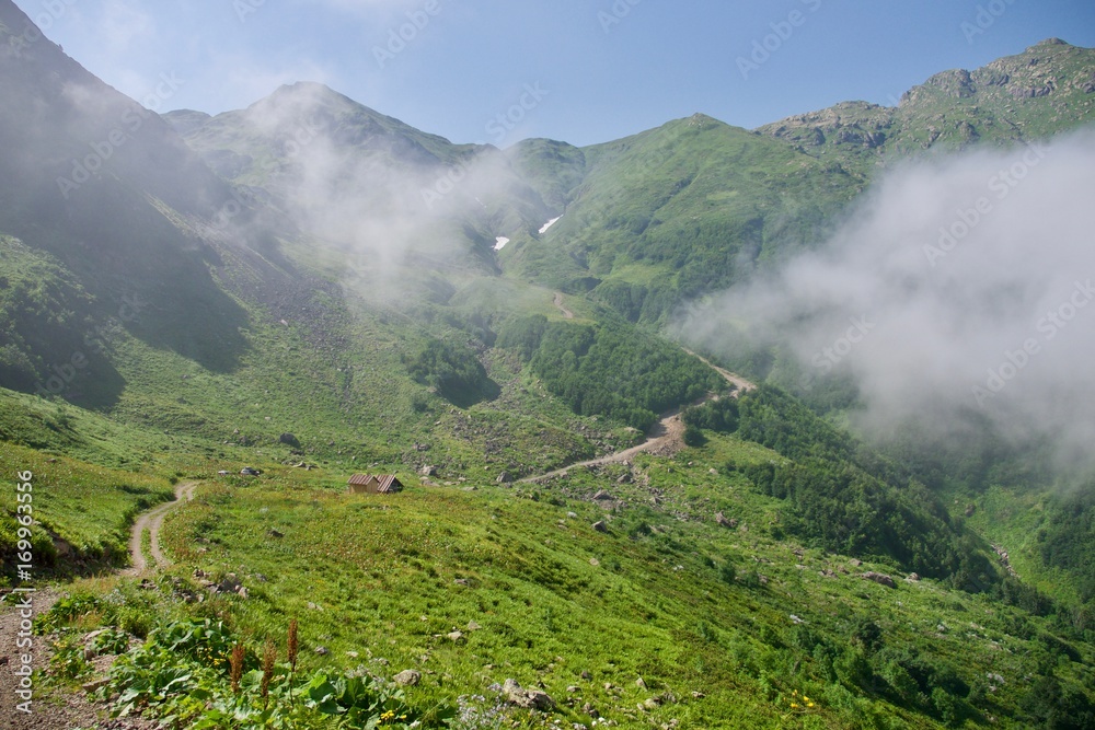 Beautiful mountain landscape with wild dirty road at summer