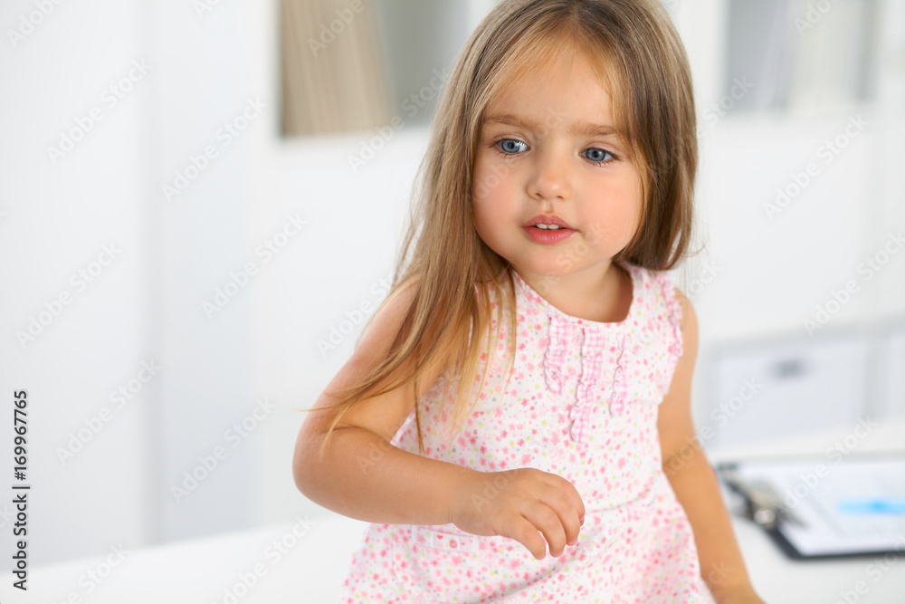 Happy little girl at health exam at doctor office. Medicine and health care concept Happy little girl at health exam at doctor office. Medicine and health care concept