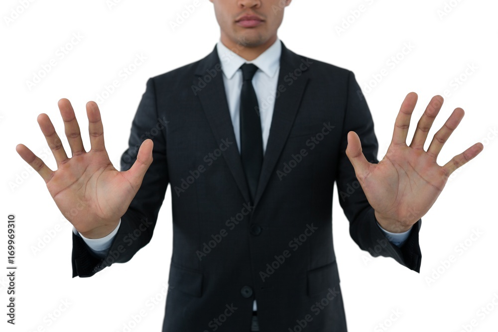 Mid section of businessman touching invisible interface Mid section of businessman touching invisible interface