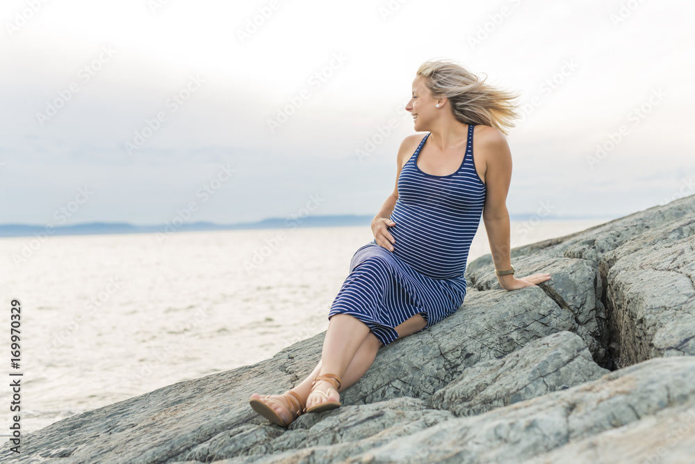 Portrait of a young beautiful blond pregnant woman on the side of the beach Portrait of a young beautiful blond pregnant woman on the side of the beach
