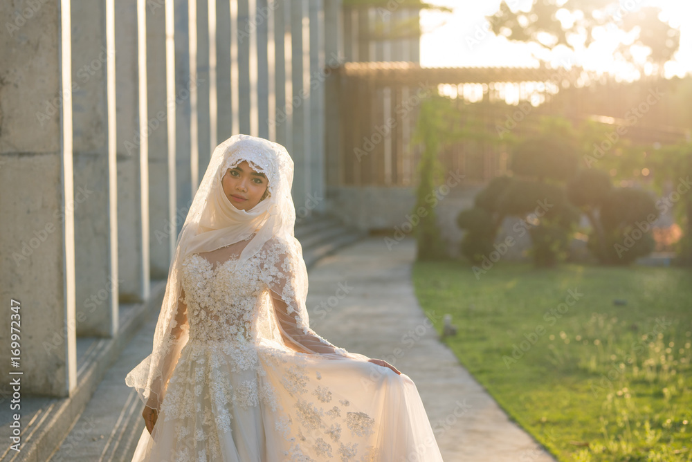 Portrait of a beautiful muslim bride with make up in white wedding dress  with beautiful white headdress natural light. Stock-Foto | Adobe Stock