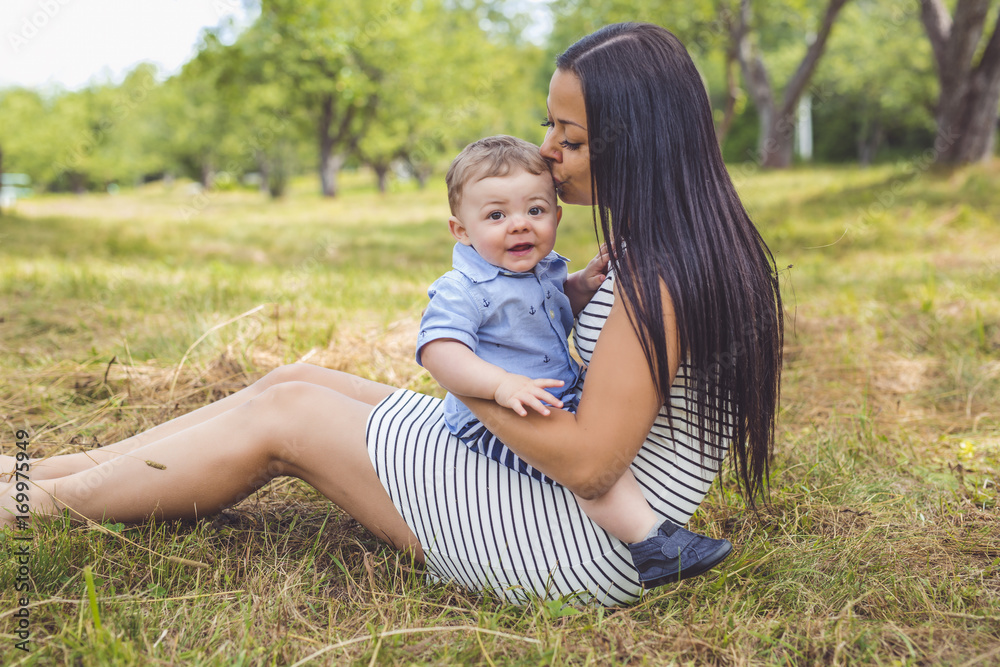 Playful woman in the garden playing with her baby son