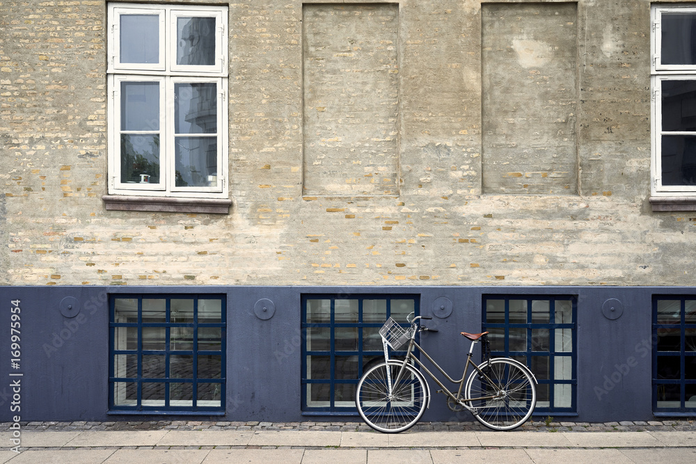 Old bike with basket parked at wall Old bike with basket parked at wall