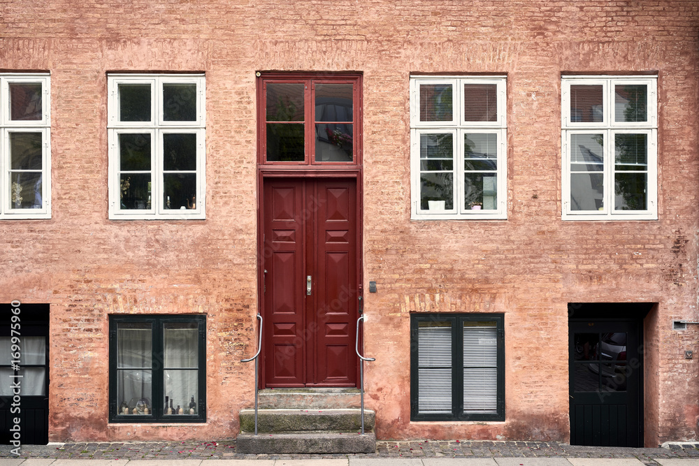 Residential house with red wooden door and windows Residential house with red wooden door and windows