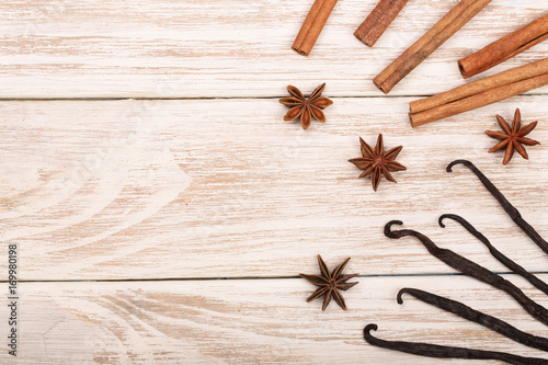 vanilla sticks, cinnamon, coffee beans and star anise on white wooden background with copy space for your text. Top view