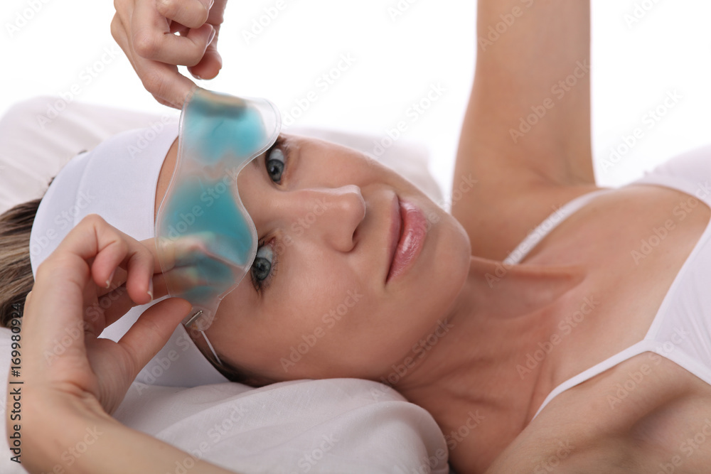 Naklejka premium Attractive young woman with enjoying cooling eye gel mask. Relaxing, Beauty concept.