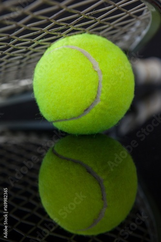 Close up of tennis racket on fluorescent yellow ball with