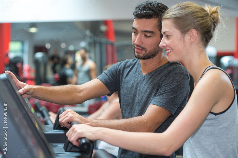 Obraz premium personal trainer helping woman working with treadmill