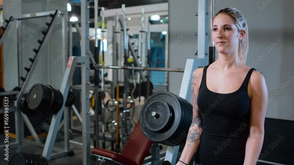 Young and sexy girl at a gym - barbell training Young and sexy girl at a gym - barbell training