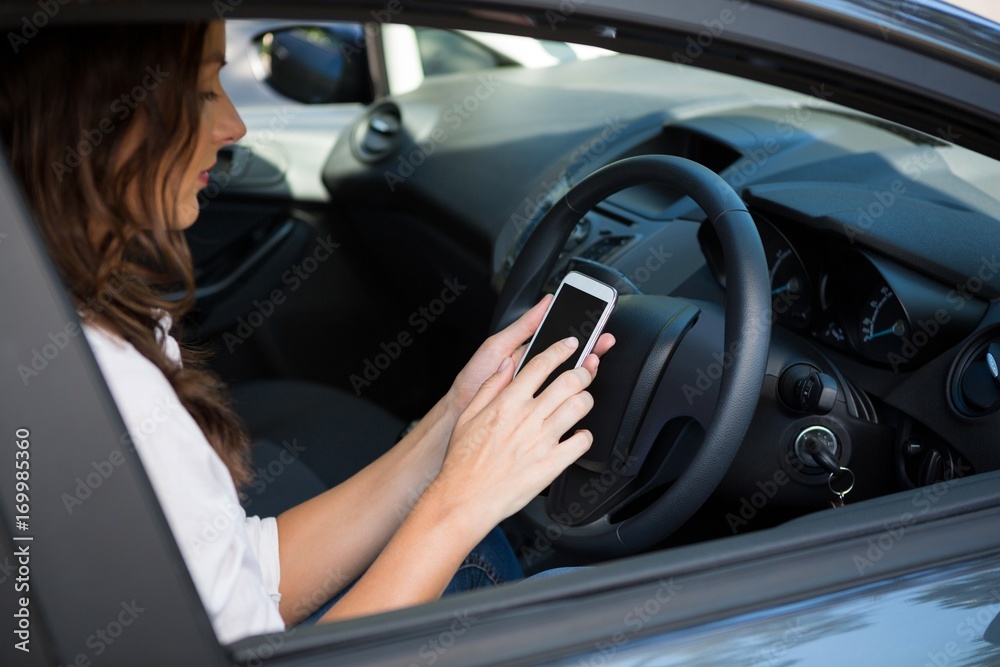 Woman using mobile phone while driving a car