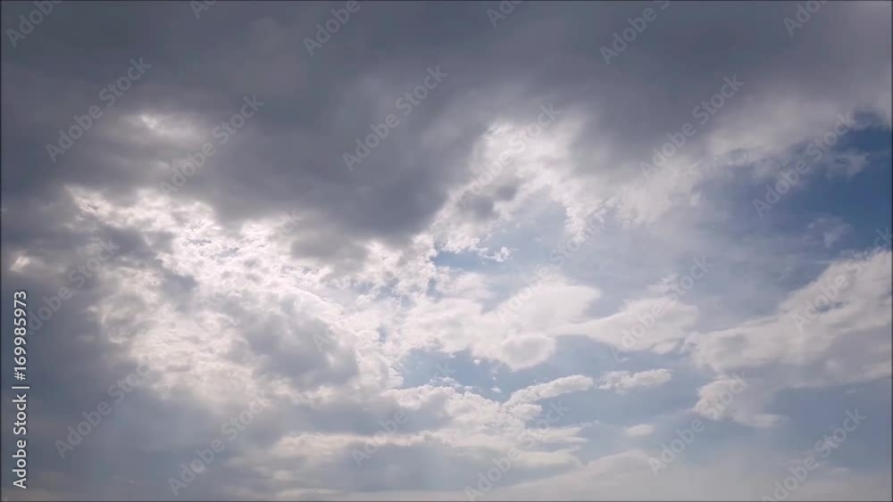 Blue sky with white, gray and black clouds. The Sun between clouds. Blue sky with white, gray and black clouds. The Sun between clouds.