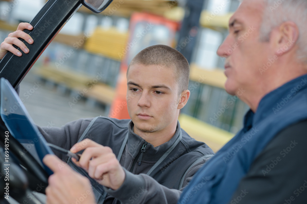 instructor teaching apprentice how to drive a heavy construction vehicle