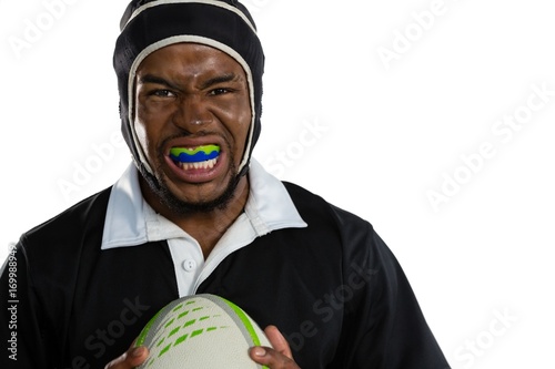 Portrait of male rugby player wearing mouthguard white holding photo
