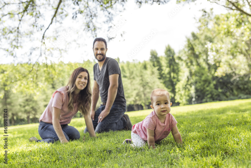 Happy mother, father and daughter in the park. Beauty nature scene with family outdoor lifestyle